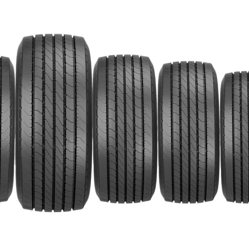 Five black tires of varying sizes aligned vertically, illustrating differences in tire width and sidewall height for tire size comparison.