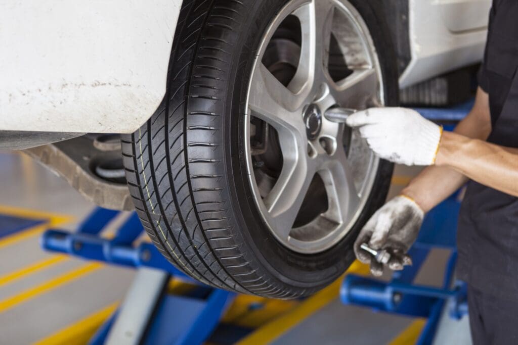 Mechanic installing used tires on car